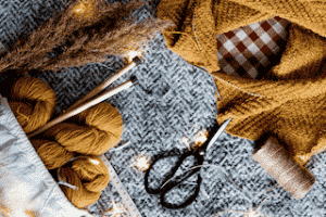 Outils pour tricoter, aiguilles et ciseaux pour faire un cadeau maison comme un plaid, un bonnet pour faire de votre noël une soirée exceptionnel et eco-responsable