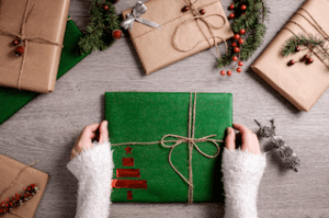 Photo avec divers cadeaux emballés avec du papier kraft et décorés avec de la ficelle et des branches c'est une des manières d'emballer des cadeaux de manière éco-responsable